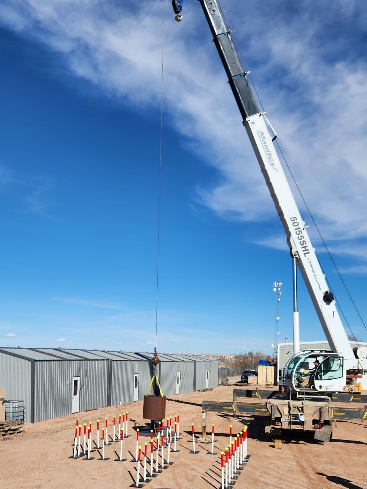 A telescopic crane with its boom extended against a blue sky